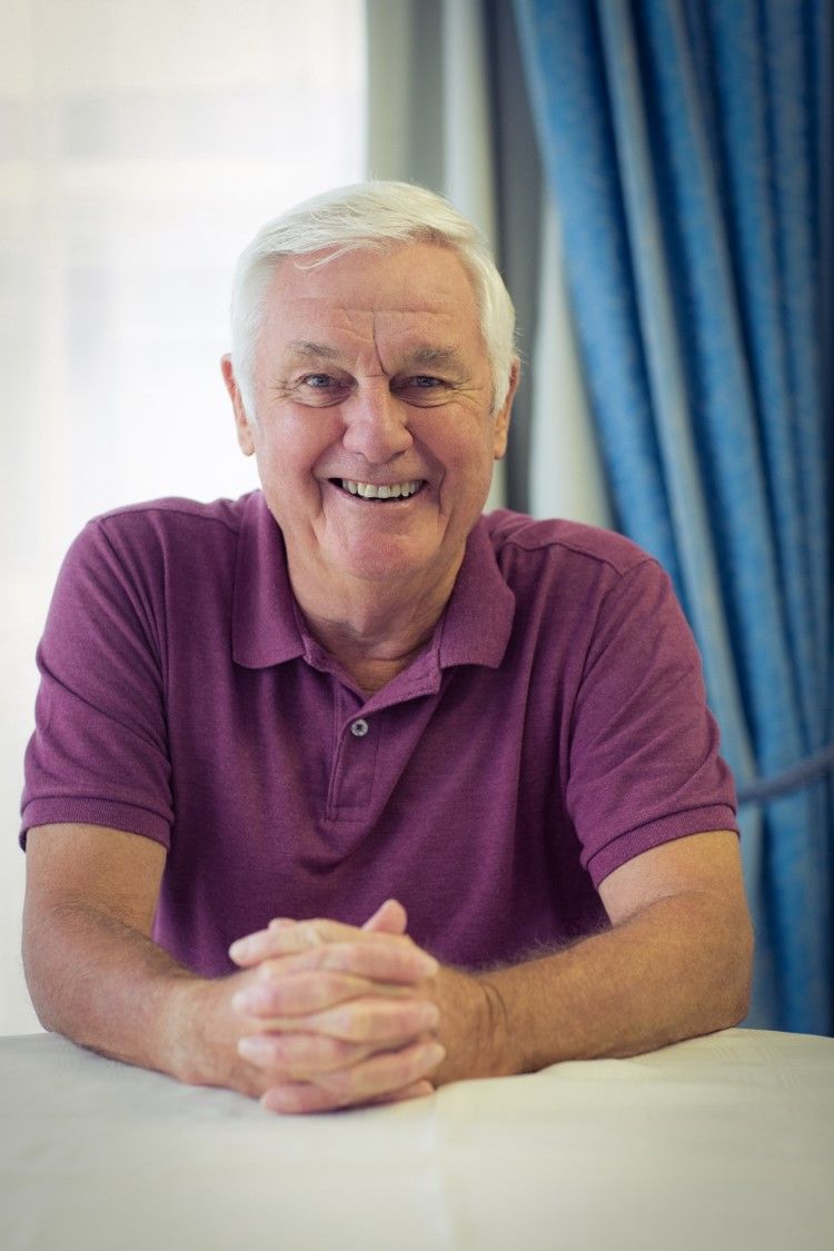 A smiling older man sitting at a table
